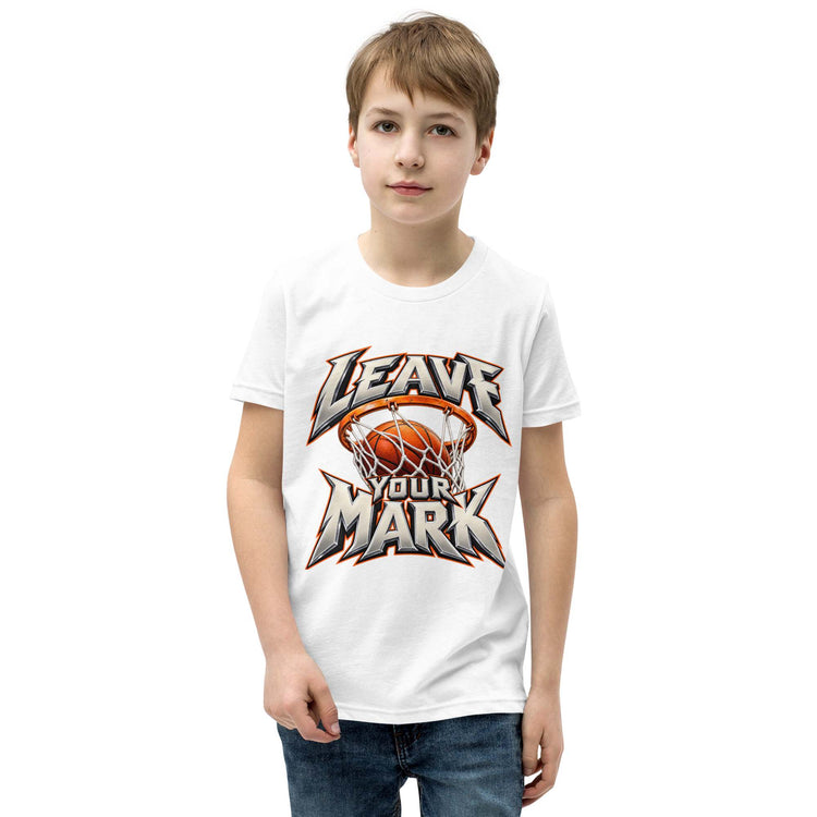 A young boy wearing a white short-sleeve t-shirt with a basketball-themed graphic that reads 'LEAVE YOUR MARK' around an orange basketball in a hoop, paired with blue jeans, set against a plain white background.